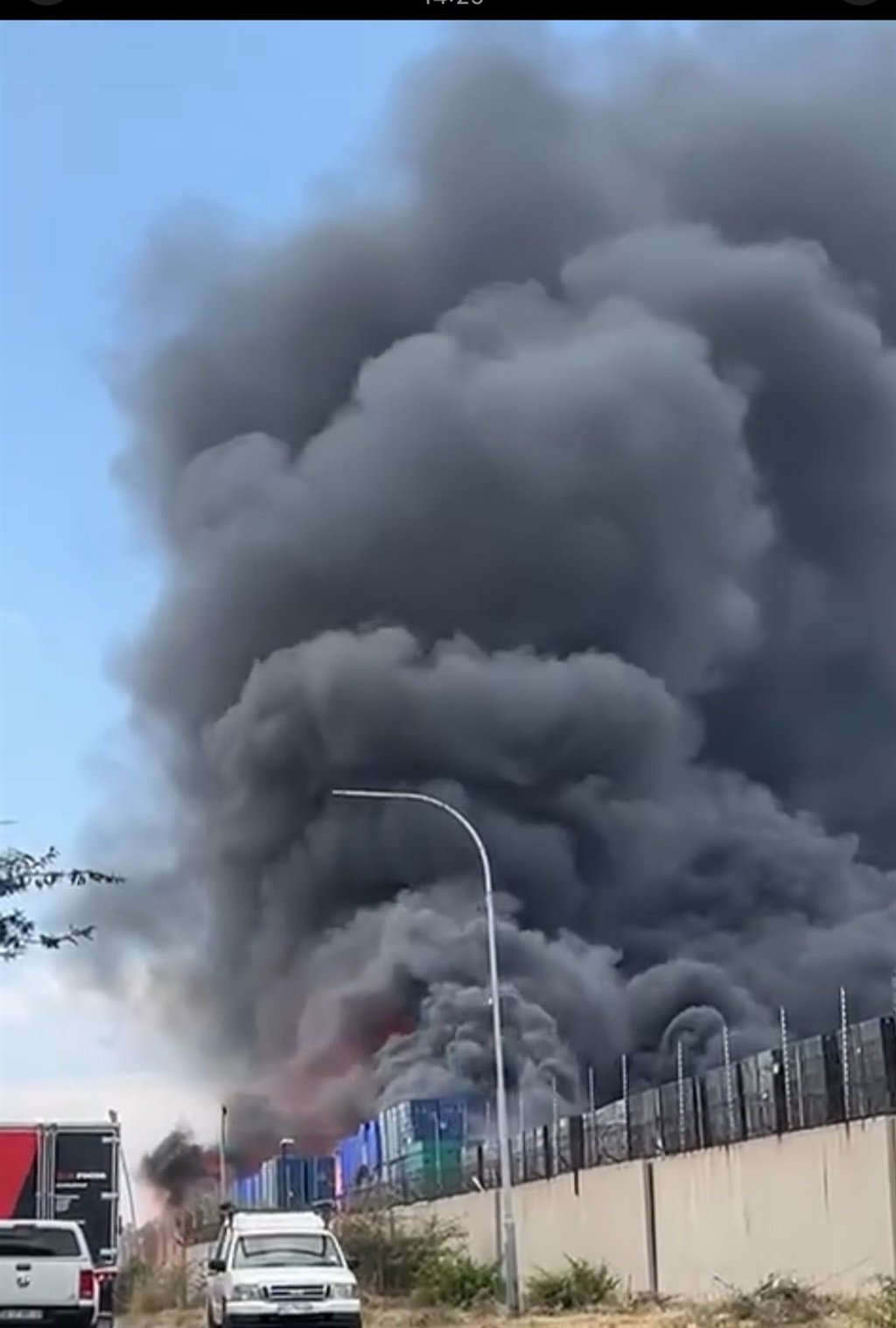 Thick smoke rises from the South African Breweries Baragwanath depot in Soweto where firefighters diligently contained a blaze that began in nearby grass and spread to outdoor crates, sparing the main building. Credit: DailySun