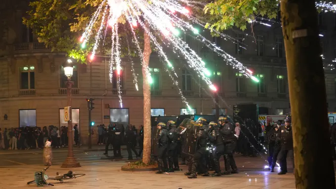 Fireworks explode over riot police officers on the Champs-Elysees in Paris. Aurelien Morissard/AP