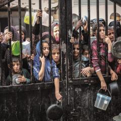 Children receive limited rations at an aid distribution site in northern Gaza. Starvation deaths have surged amid tightened Israeli restrictions and collapsed ceasefire talks. Image: Haaretz.