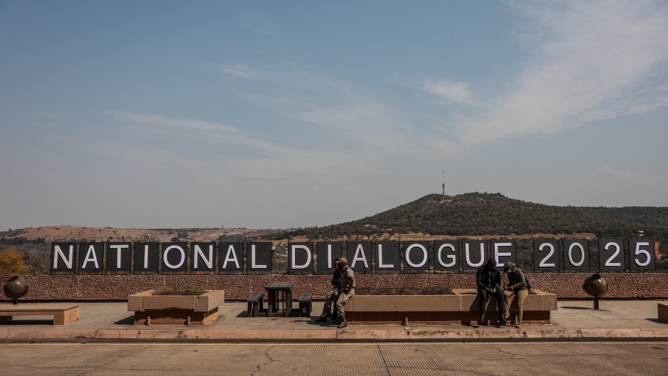 People are seated beside a sign that reads "National Dialogue 2025" during the inaugural National Convention held at the University of South Africa (UNISA) in Pretoria on August 15, 2025.