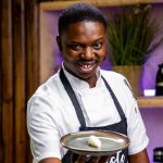 Chef Lucky Masinya proudly presents one of his creations during his time on "The Taste Master SA." His culinary journey is an inspiring tale of perseverance and passion.