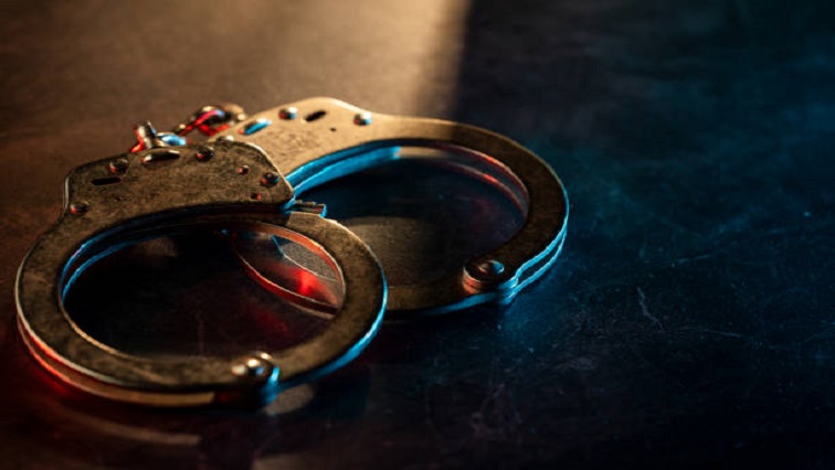 Metal handcuffs on a dark surface symbolizing arrests following the robbery attempt DA MPs incident.