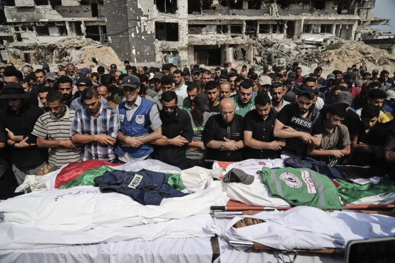 Palestinian public praying over journalists' bodys in Gaza