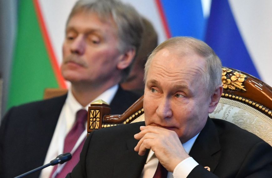 Kremlin spokesperson Dmitry Peskov behind Ukraine President Vladimir Putin