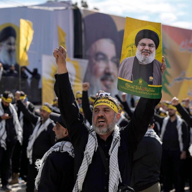 Hezbollah supporters marching while Lebanese cabinet discuss disarmament plan