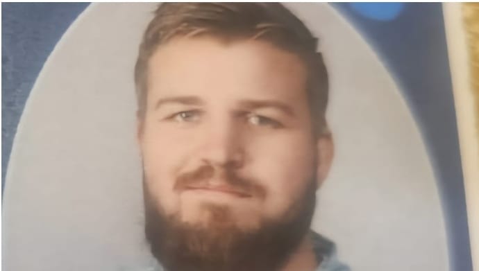 Portrait-style photograph of Adam Edwards with a beard, light hair, and a neutral expression.