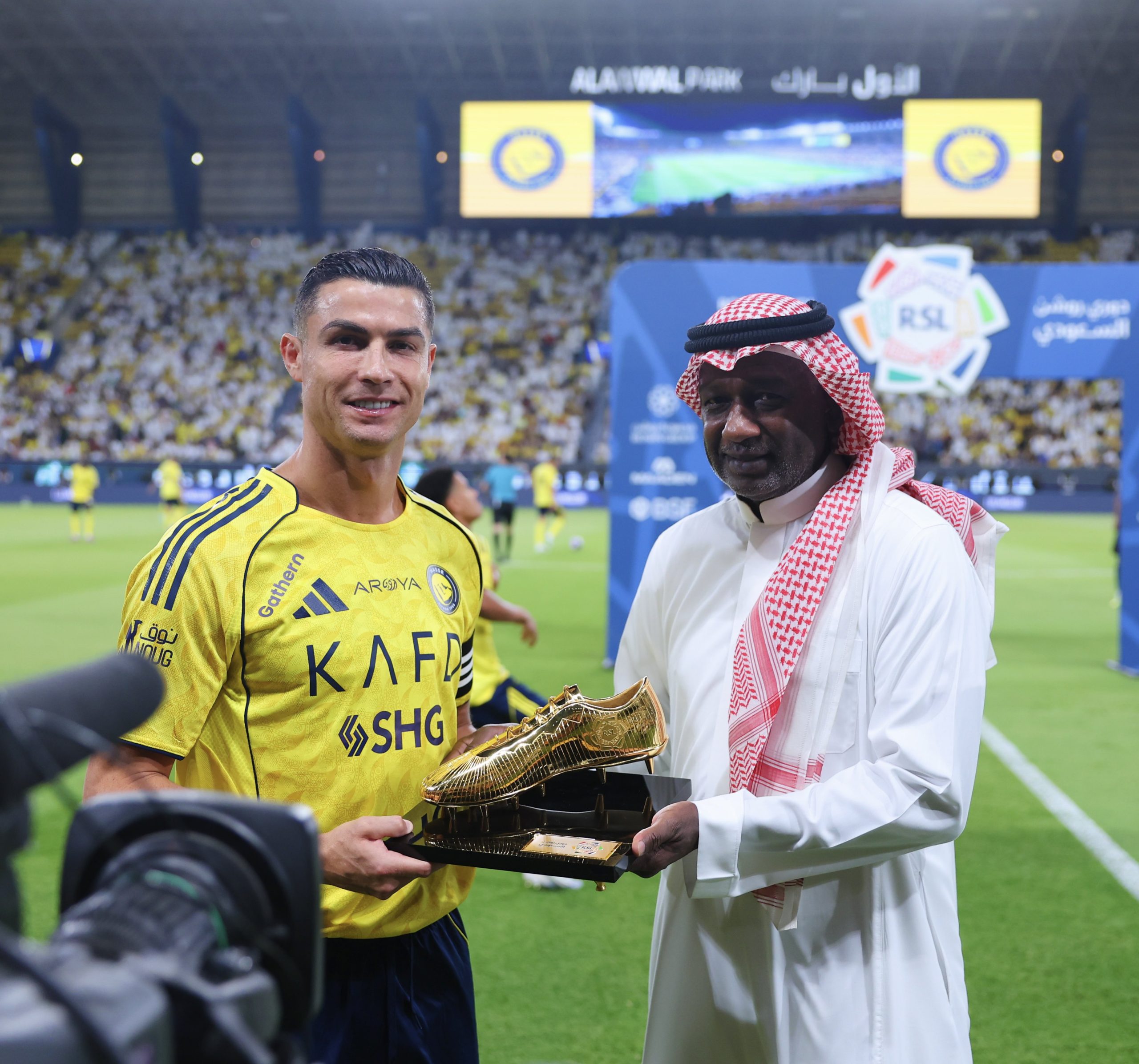 Majed Abdullah handing Ronaldo a Golden Boot award.