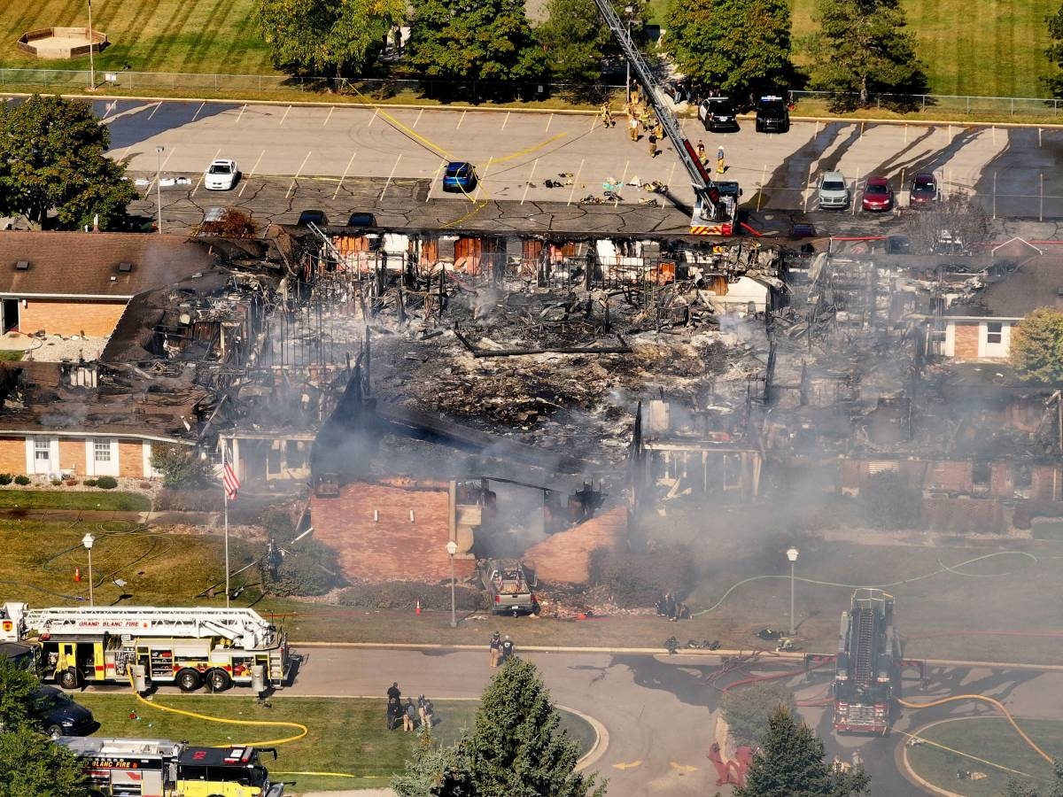Church Attack Leaves 4 Dead in Shocking Michigan Incident 1 Aerial view of a burned church building in Michigan following a tragic attack; firefighters and emergency vehicles are on the scene with smoke still rising from the ruins.
