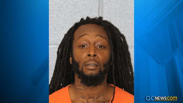 Ukrainian Refugee Stabbing Case suspect Decarlos Brown in a mugshot wearing an orange prison uniform against a gray background.