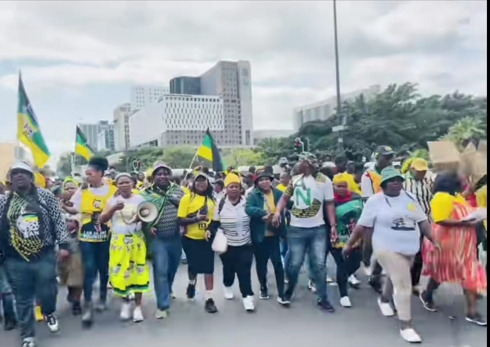 Khayelitsha residents march for electricity and sanitation, with a group of people holding flags, megaphones, and signs as they walk towards Parliament, demanding basic services such as electricity and safer sanitation.