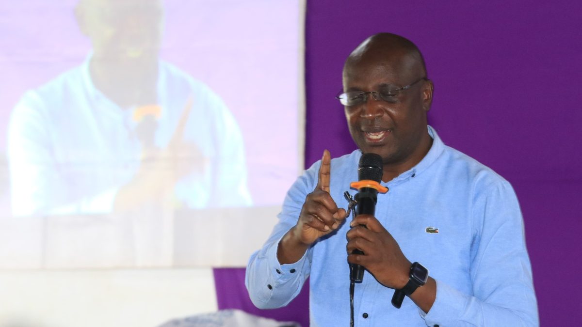 Image Credit: Facebook Hon. Wycliffe Wafula Wangamati Former Bungoma Governor Wycliffe Wangamati of Kenya speaking into a microphone, wearing glasses and a light blue shirt, with his right index finger raised.