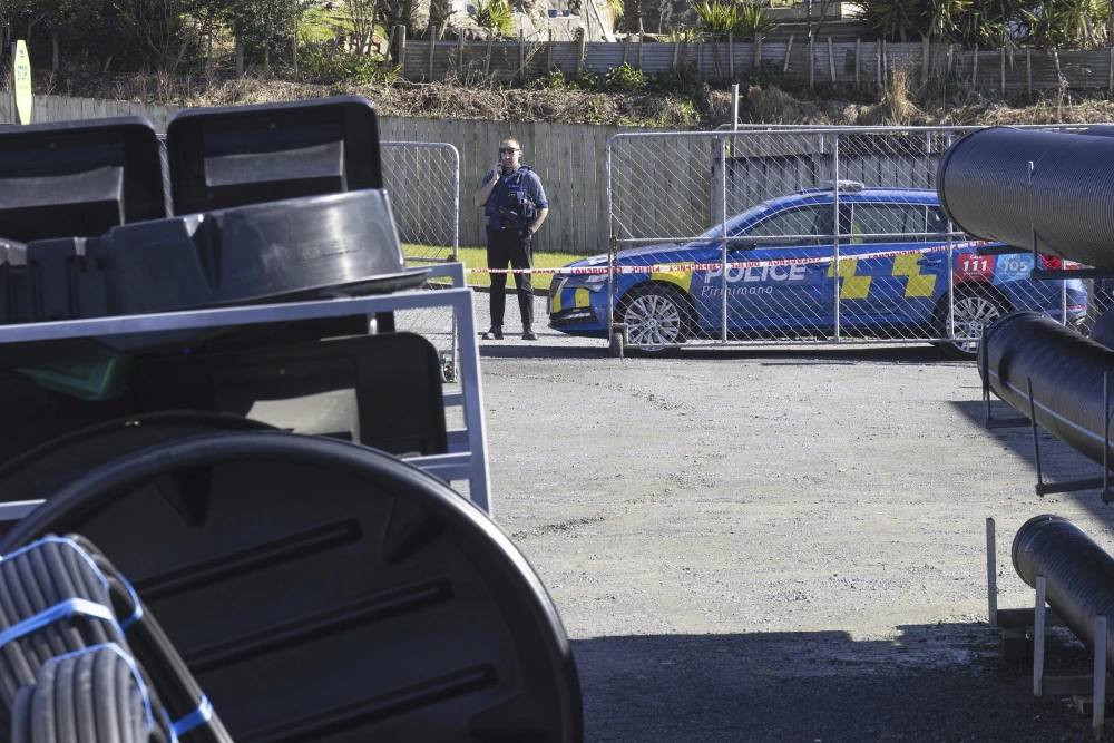 NZ dad shot by police scene with officer guarding taped-off area near patrol car in New Zealand