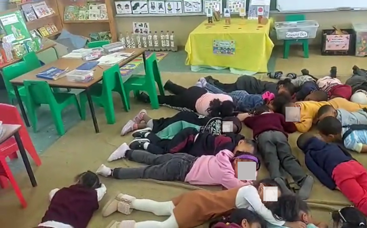 Grade R teacher Sinead Majiet comforts young learners at Yellowwood Primary School by playing calming music as they lie on the classroom floor, a powerful moment of managing classroom fear during violence.