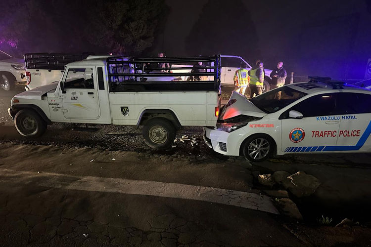 Justice system failure shown as a police vehicle involved in a crash with a white truck on a dark road in KwaZulu-Natal, highlighting the risks officers face while enforcing road laws.