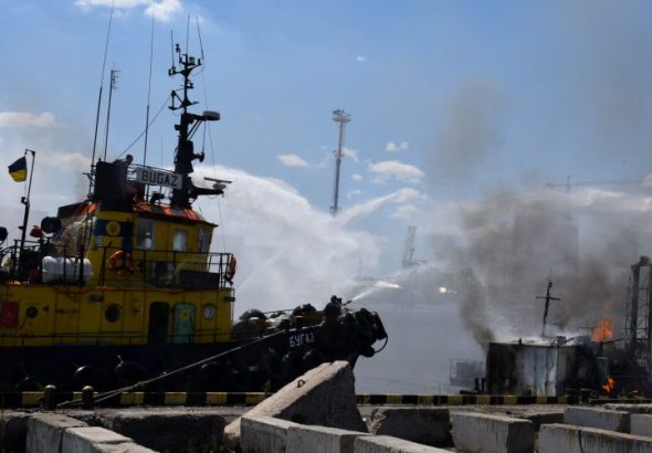 A massive fire engulfs containers at the port of Pivdennyi in Odesa, Ukraine, following a Russian attack, with emergency services responding to the scene.