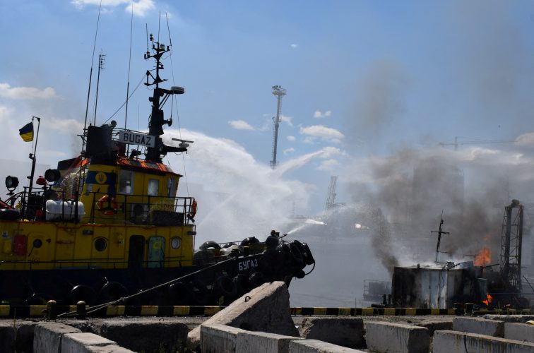 A massive fire engulfs containers at the port of Pivdennyi in Odesa, Ukraine, following a Russian attack, with emergency services responding to the scene.