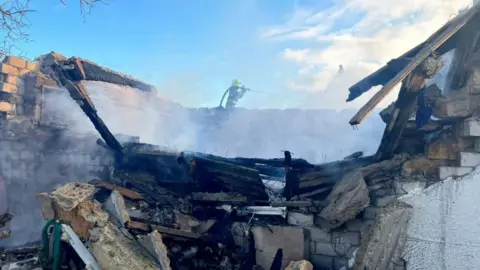 Firefighters work at the site of a civilian vessel hit during a Russian missile strike in Chornomorsk, Odesa region, Ukraine.